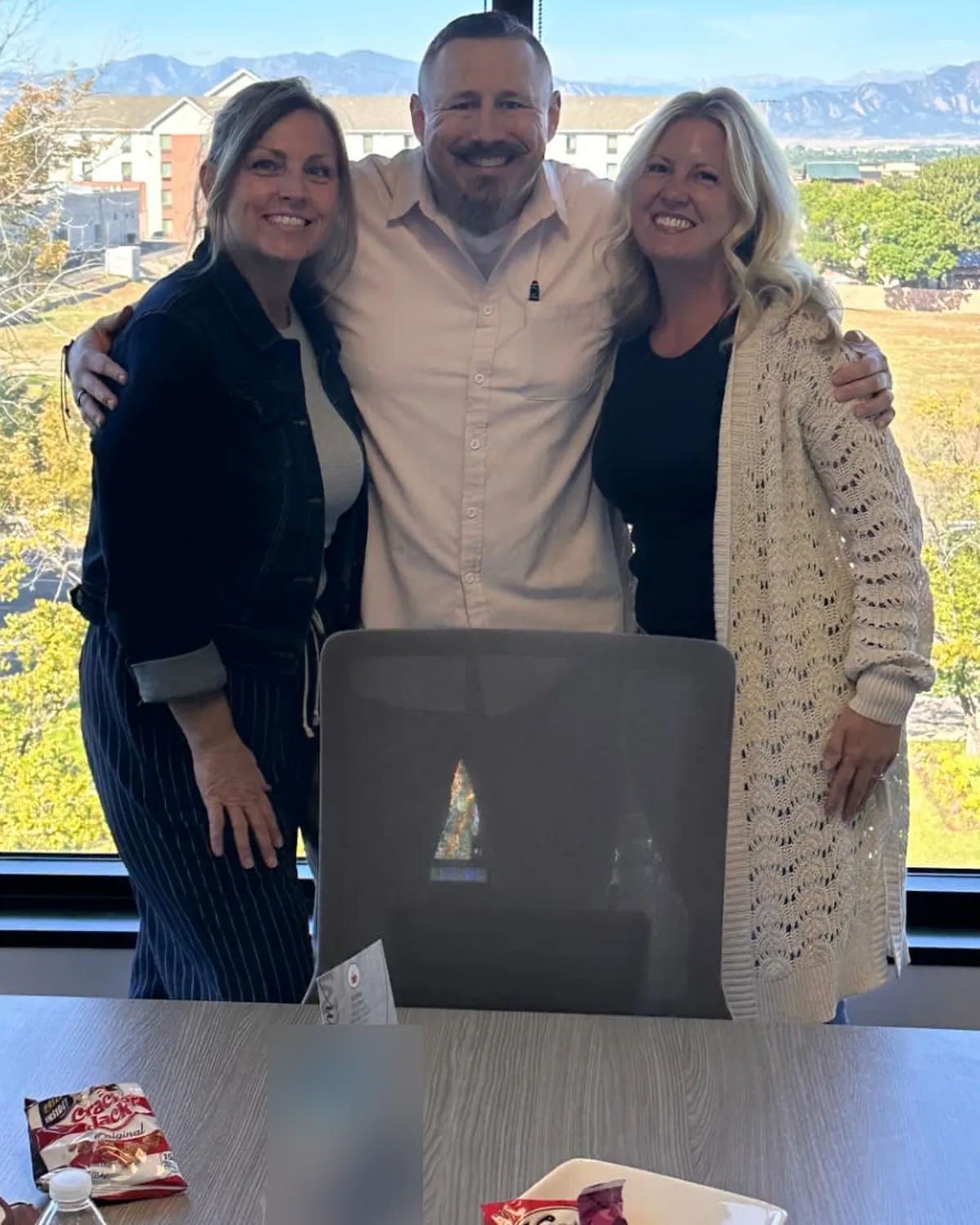 Brandy Unruh, REALTOR® with Compass, with clients at a closing overlooking the Front Range
